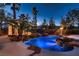 Tranquil pool area with rock waterfall and lush landscaping at 3235 S Tioga Way, Las Vegas, NV 89117