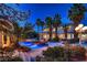 Inviting backyard pool with rock features, lush palms, and ambient lighting at 3235 S Tioga Way, Las Vegas, NV 89117