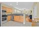 Modern kitchen with granite counters, stainless steel appliances, and maple cabinets, open to the living room at 337 Mattie Brook Ave, Henderson, NV 89015