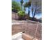 View of the backyard with dirt, palm trees, and a brick fence at 3480 E Hacienda Ave, Las Vegas, NV 89120