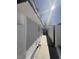 Exterior view of the side of a white home with stucco, highlighting the walkway and privacy fencing at 3480 E Hacienda Ave, Las Vegas, NV 89120