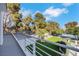 Backyard featuring lush greenery, mature trees, and an outdoor tennis court at 3860 Hildebrand Ln, Las Vegas, NV 89121