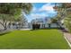 Expansive backyard features lush green grass, with a view of the modern home and pool at 3860 Hildebrand Ln, Las Vegas, NV 89121