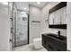 A modern bathroom with a marble shower, a sleek vanity, and black fixtures at 3860 Hildebrand Ln, Las Vegas, NV 89121
