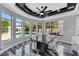 Stylish dining area with a modern ceiling fan, marble floors, and large windows overlooking the pool at 3860 Hildebrand Ln, Las Vegas, NV 89121