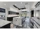 Modern kitchen with waterfall island, dark cabinets, stainless steel appliances, and stylish pendant lighting at 3860 Hildebrand Ln, Las Vegas, NV 89121