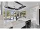 Bright kitchen featuring a large island, farmhouse sink, and views of the outdoor pool area at 3860 Hildebrand Ln, Las Vegas, NV 89121