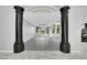 An open-concept living room with marble flooring, natural light, and decorative columns at 3860 Hildebrand Ln, Las Vegas, NV 89121