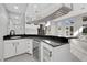 A modern wet bar features a black countertop, white cabinets, and a wine cooler at 3860 Hildebrand Ln, Las Vegas, NV 89121