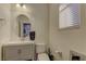 Well-lit bathroom featuring a modern vanity, toilet, and round mirror with natural light from a window at 426 Port Reggio St, Las Vegas, NV 89138