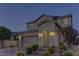 Inviting two-story home featuring a brick driveway, manicured bushes, and a two-car garage with beautiful exterior lighting at 426 Port Reggio St, Las Vegas, NV 89138