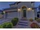 A welcoming two-story home showcasing brick steps to the front door, manicured bushes, and a two-car garage at 426 Port Reggio St, Las Vegas, NV 89138