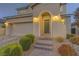 Inviting front entrance featuring an arched doorway, illuminated sconces and well-manicured landscaping at 426 Port Reggio St, Las Vegas, NV 89138