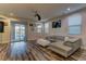 Bright living room with wood floors, a comfy leather sofa, and seamless indoor-outdoor flow to a pool at 426 Port Reggio St, Las Vegas, NV 89138