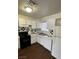 This kitchen features white cabinets, black appliances, and a checkered backsplash at 4341 San Mateo St, North Las Vegas, NV 89032