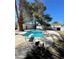 Backyard pool with a diving board, lush foliage, and additional buildings at 4560 Rancho Hills Dr, Las Vegas, NV 89119