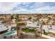 Backyard view featuring a covered patio, artificial grass, and desert landscaping in a residential neighborhood at 4690 San Benito St, Las Vegas, NV 89121
