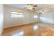 Bright bedroom featuring ceiling fan, wood floors, window with blinds, and mirrored closet doors at 4690 San Benito St, Las Vegas, NV 89121
