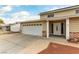 A tan home featuring brick accents on the pillars, white garage door and desert landscaping at 4690 San Benito St, Las Vegas, NV 89121