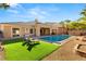 Beautiful backyard with a sparkling pool, lush lawn, and covered patio, ideal for outdoor gatherings at 50 Carolina Cherry Dr, Las Vegas, NV 89141