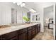Bathroom featuring double sinks, granite countertops, and dark wood cabinets at 50 Carolina Cherry Dr, Las Vegas, NV 89141