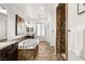 Well lit bathroom with granite countertops, shower stall and large soaking tub at 50 Carolina Cherry Dr, Las Vegas, NV 89141
