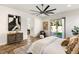 Bright bedroom with a large ceiling fan, plush carpet, and glass door to the yard and pool at 50 Carolina Cherry Dr, Las Vegas, NV 89141