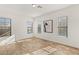 Bright, empty living room features tile floors and plenty of natural light from three large windows at 50 Carolina Cherry Dr, Las Vegas, NV 89141