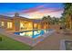 A sparkling pool with a brick trim, desert landscaping, and a covered outdoor patio area at 50 Carolina Cherry Dr, Las Vegas, NV 89141