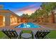 Sparkling pool with lush landscaping, lounge chairs, and an outdoor seating area at 50 Carolina Cherry Dr, Las Vegas, NV 89141