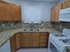 This kitchen features wood cabinets, granite counters, mosaic backsplash, and stainless sink at 5044 S Rainbow Blvd # 106, Las Vegas, NV 89118
