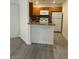 Bright kitchen with wood cabinetry, breakfast bar, granite counters, and modern appliances at 5044 S Rainbow Blvd # 106, Las Vegas, NV 89118