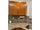 Granite counters and mosaic backsplash on wood cabinets with stainless steel sink at 5044 S Rainbow Blvd # 106, Las Vegas, NV 89118