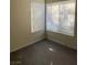 Bedroom features modern gray wood-look flooring and a sunny view through windows with blinds at 5115 Blossom Ave, Las Vegas, NV 89142