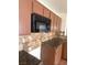 Kitchen showcasing wood cabinets, granite countertops, and a built-in microwave at 5115 Blossom Ave, Las Vegas, NV 89142