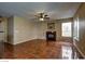 Open concept living room with tile flooring, fireplace, ceiling fan, and large windows at 5115 Blossom Ave, Las Vegas, NV 89142