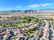 Expansive aerial view of the community with houses, golf course, mountains and clear blue skies at 5467 Eleganza Ave, Pahrump, NV 89061