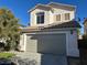 Two-story home features a neutral exterior, a two-car garage, a tile roof and tidy landscaping at 5758 Yellowcrest Ct, Las Vegas, NV 89113