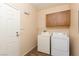 Functional laundry room with washer, dryer, wooden cabinets, and a convenient side door at 5855 Valley Dr # 1107, North Las Vegas, NV 89031