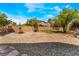 Landscaped backyard with a gravel area, a small grassy space, a fountain, and a rustic fence for privacy at 5872 Revital Ct, Las Vegas, NV 89131