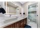 Bright bathroom features a marble countertop, dual sinks, a backlit mirror, and a beautifully tiled shower at 5872 Revital Ct, Las Vegas, NV 89131