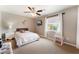 Comfortable bedroom with a ceiling fan, window with curtains, nightstand, and a pink cushioned bench at 5872 Revital Ct, Las Vegas, NV 89131