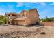 Inviting two-story home featuring a balcony, three-car garage, and desert landscaping at 5872 Revital Ct, Las Vegas, NV 89131