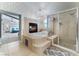 Bright main bathroom boasting a soaking tub, a fireplace, a separate glass shower and decorative tile work at 5872 Revital Ct, Las Vegas, NV 89131