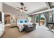 Spacious main bedroom with a ceiling fan, balcony access, and a sitting area. The walls are light gray and there are white furniture at 5872 Revital Ct, Las Vegas, NV 89131