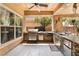 Covered outdoor kitchen equipped with stainless steel appliances, a built-in grill, and a bar area for entertaining guests at 5872 Revital Ct, Las Vegas, NV 89131