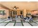 Covered patio area featuring comfortable seating, ceiling fans, and a view of the backyard with lush landscaping at 5872 Revital Ct, Las Vegas, NV 89131