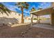 Private backyard with covered patio, desert landscaping, and mature palm trees at 5934 Reflection Point Ct, Las Vegas, NV 89110