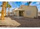 Desert landscaped backyard featuring covered patio, stucco walls, and mature palm trees at 5934 Reflection Point Ct, Las Vegas, NV 89110