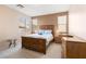 Comfortable bedroom with a wooden bed frame, matching furniture, and natural light from the windows at 5934 Reflection Point Ct, Las Vegas, NV 89110